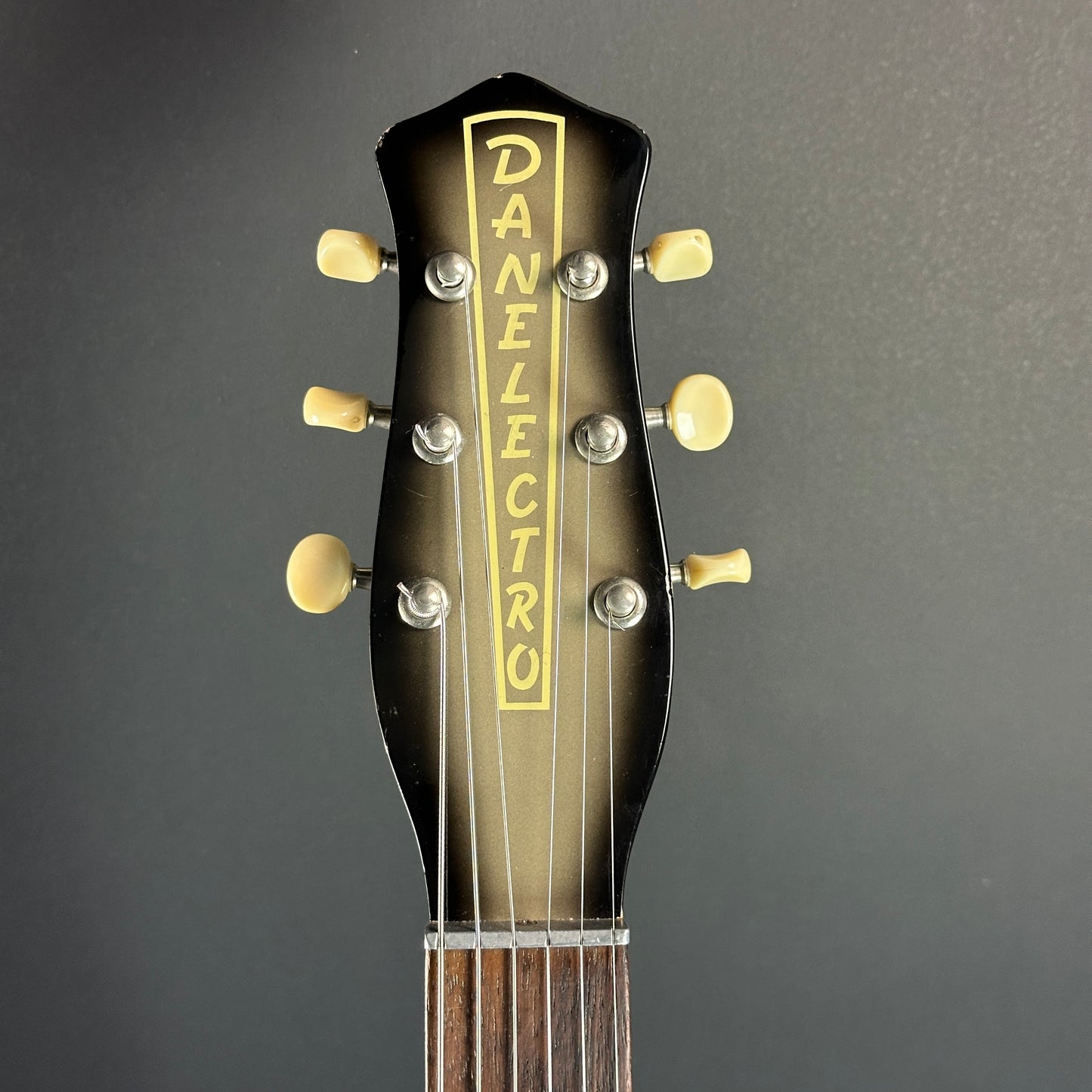 Front of headstock of Used Danelectro '59 DC Blackburst.