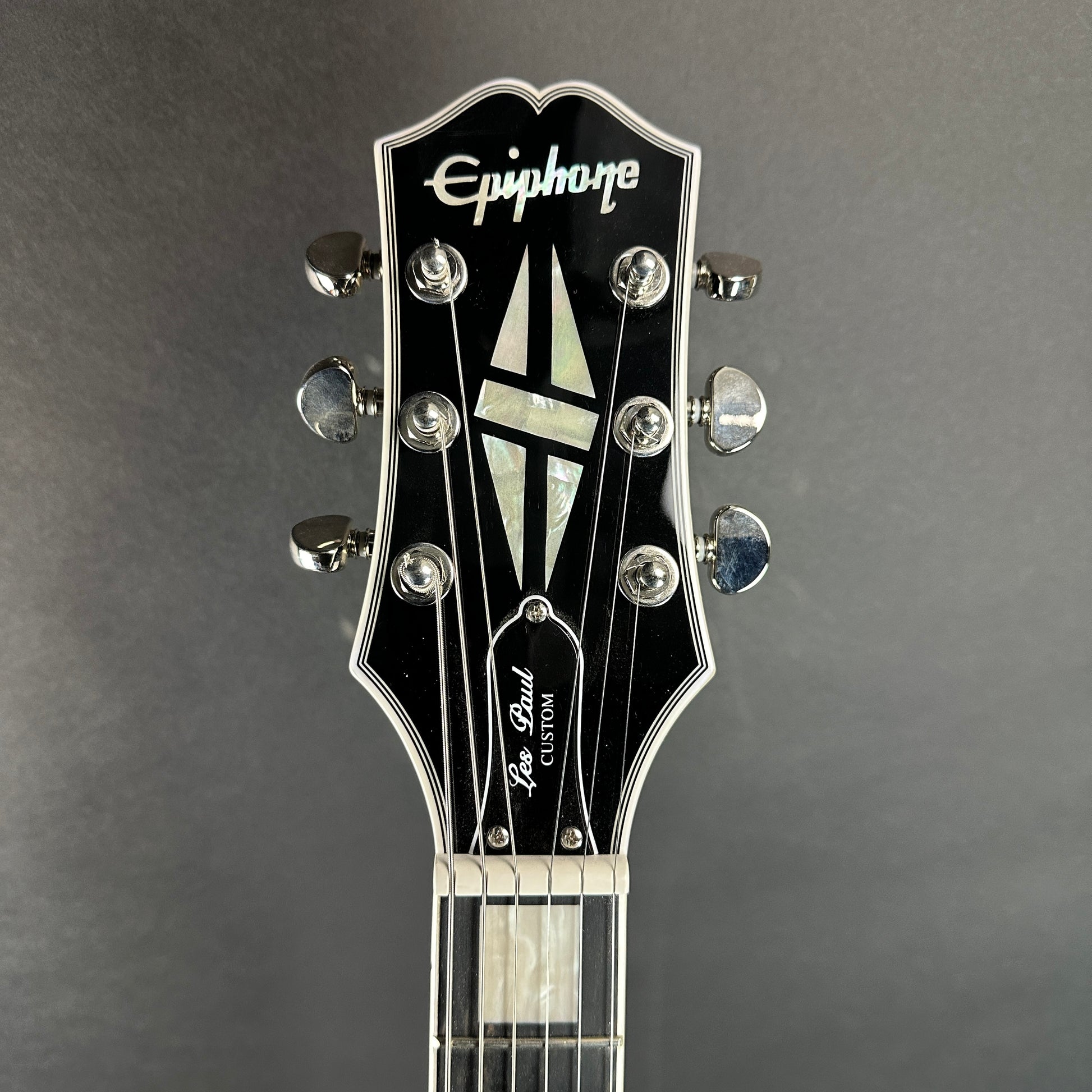 Front of headstock of Used Epiphone Les Paul Custom Silverburst.