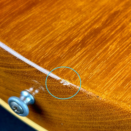 Chip near bottom strap button of Used Gibson Custom 1957 Les Paul Gold Top.