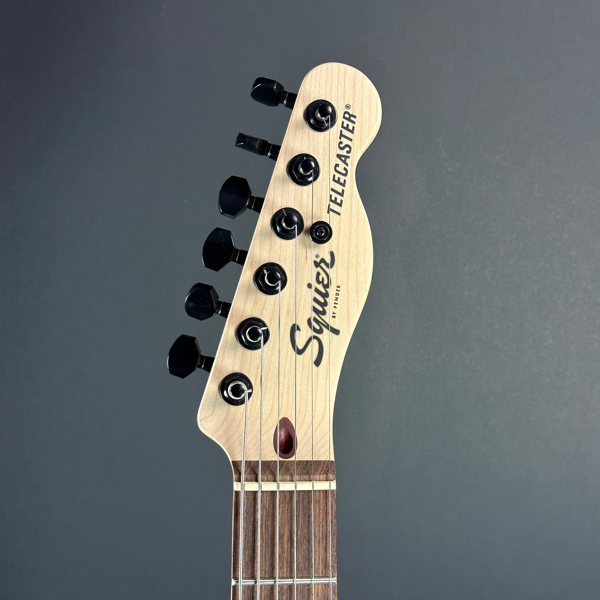 Front of headstock of Used Squier Jim Root Tele Black.