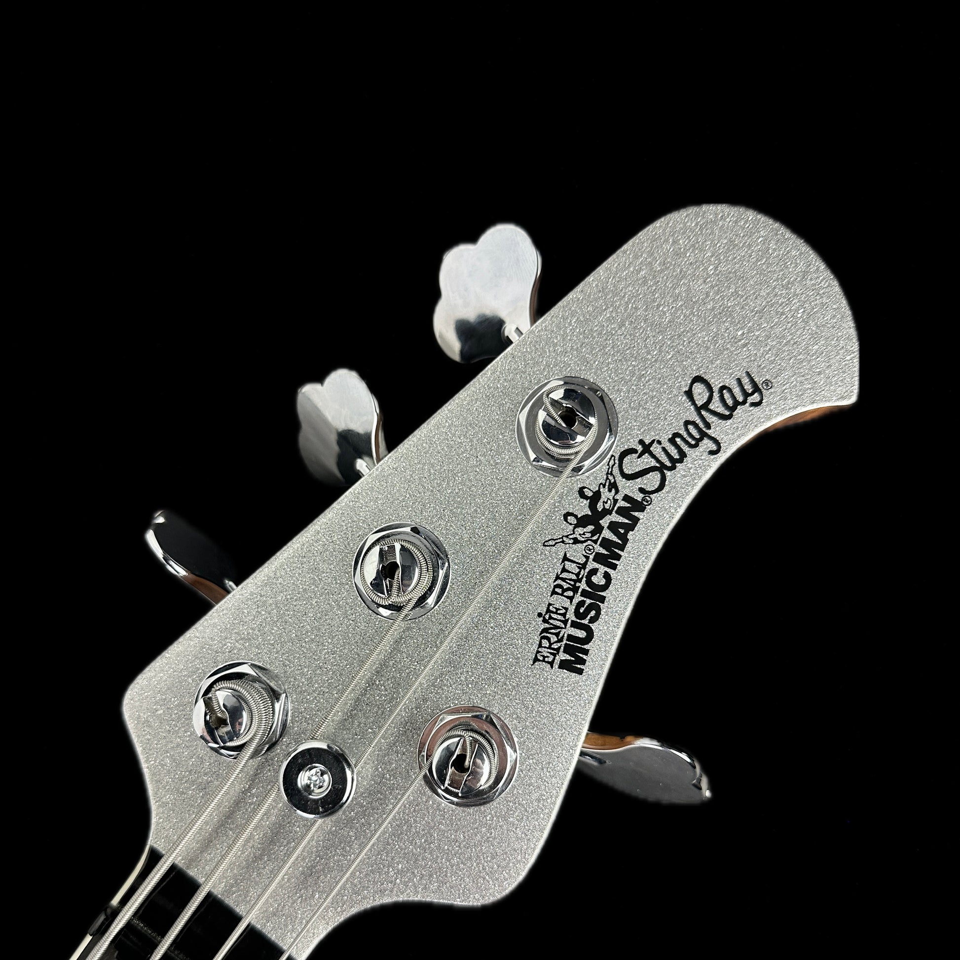 Front of headstock of Used Ernie Ball Musicman Stingray Ball Family Reserve Silver Sparkle.