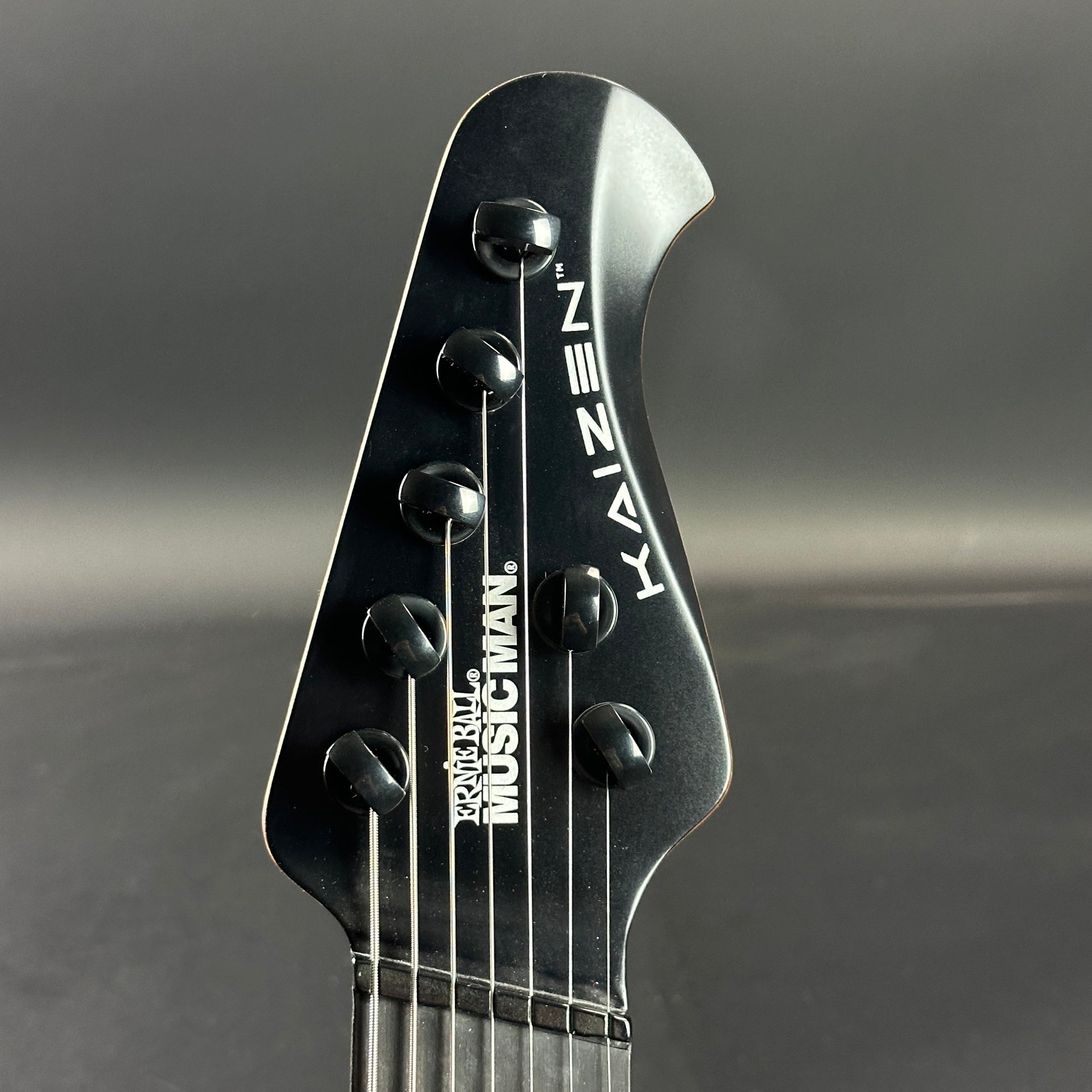 Front of headstock of Used Ernie Ball Music Man Kaizen 7 Apollo Black.