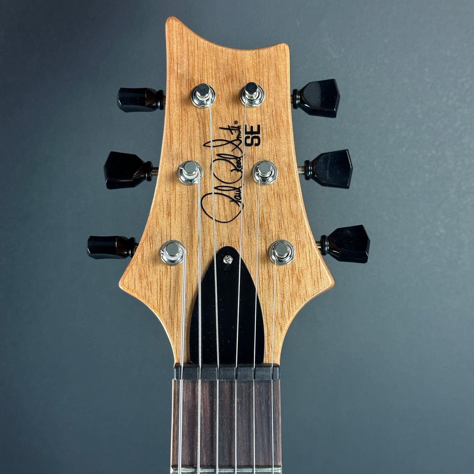 Front of headstock of Used PRS SE Paul's Guitar Charcoal Fade.