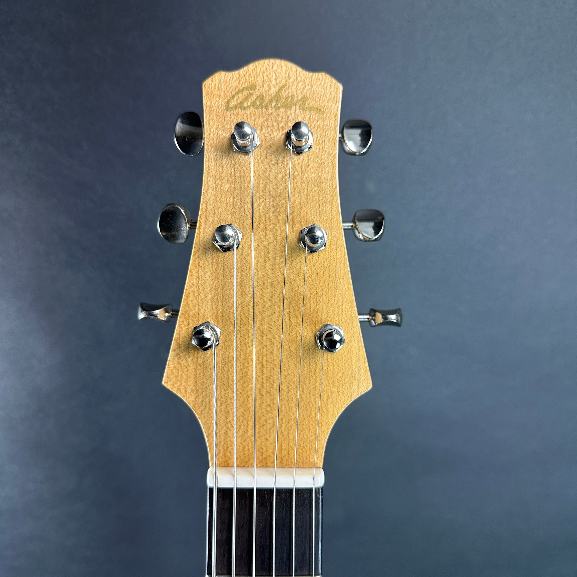 Front of headstock of Used 2022 Asher HT DLX Korina.