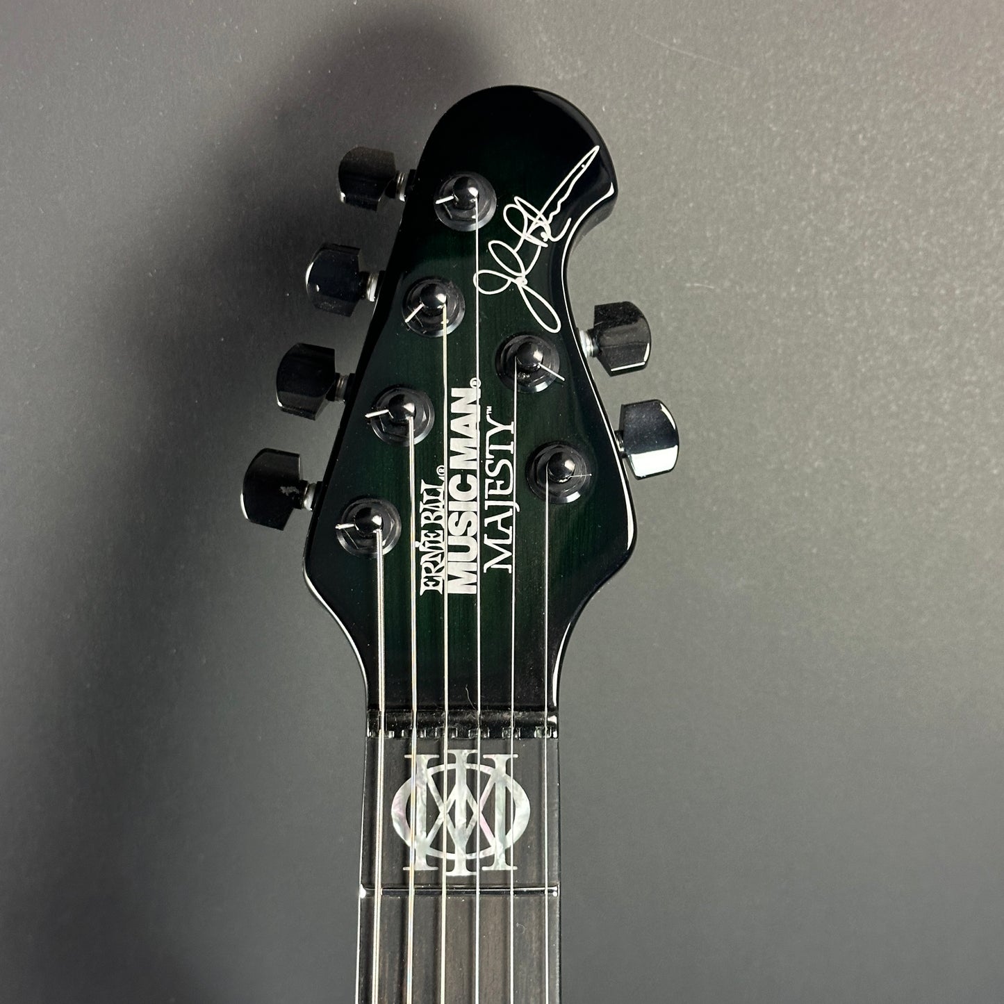 Front of headstock of Used Ernie Ball MusicMan Majesty 6 John Petrucci Gravity Green.