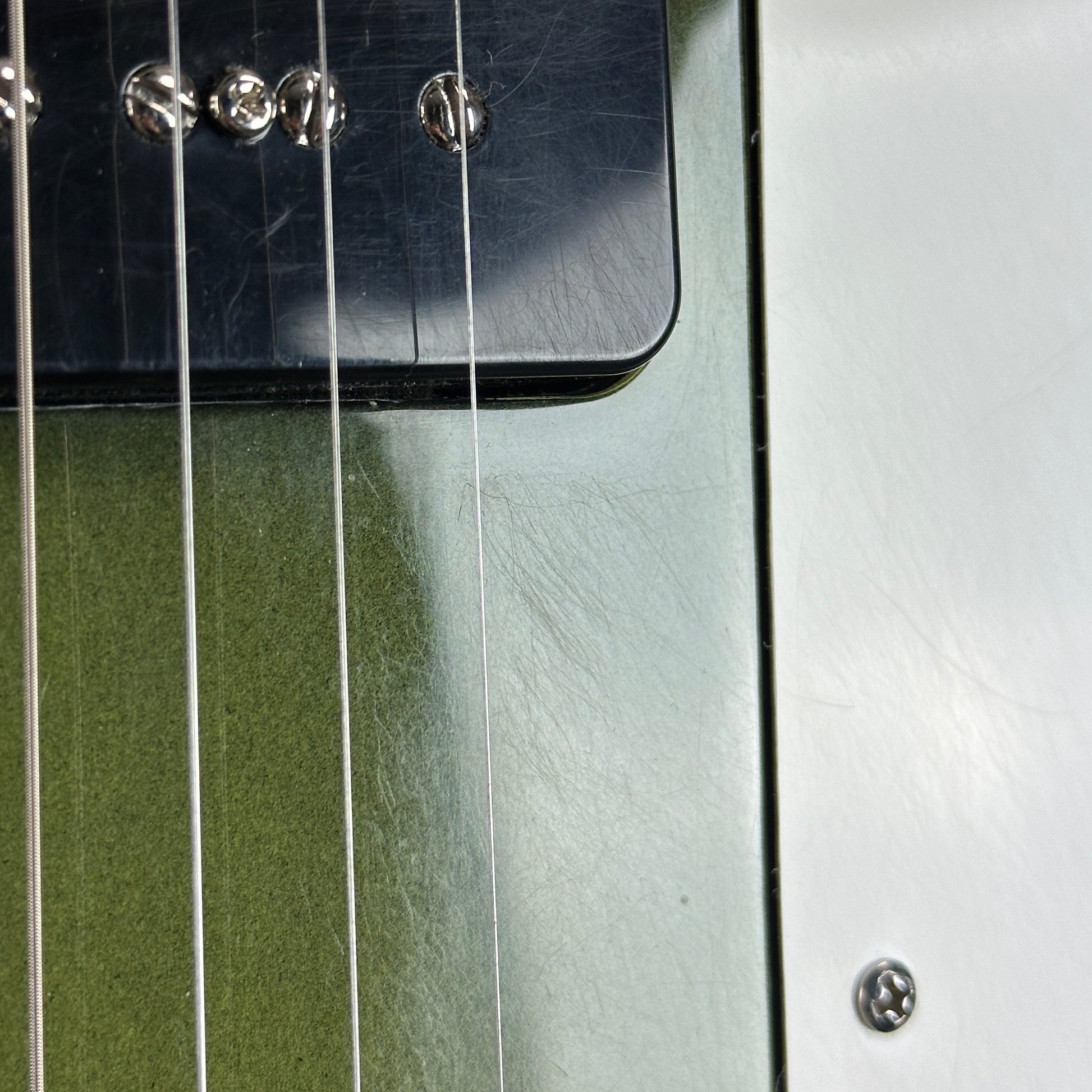 Scratches near pickups of Used Reverend Warwick DAW Avocado Burst.