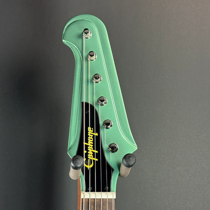 Front of headstock of Used Epiphone Inspired by Gibson Custom 1963 Firebird Inverness Green.