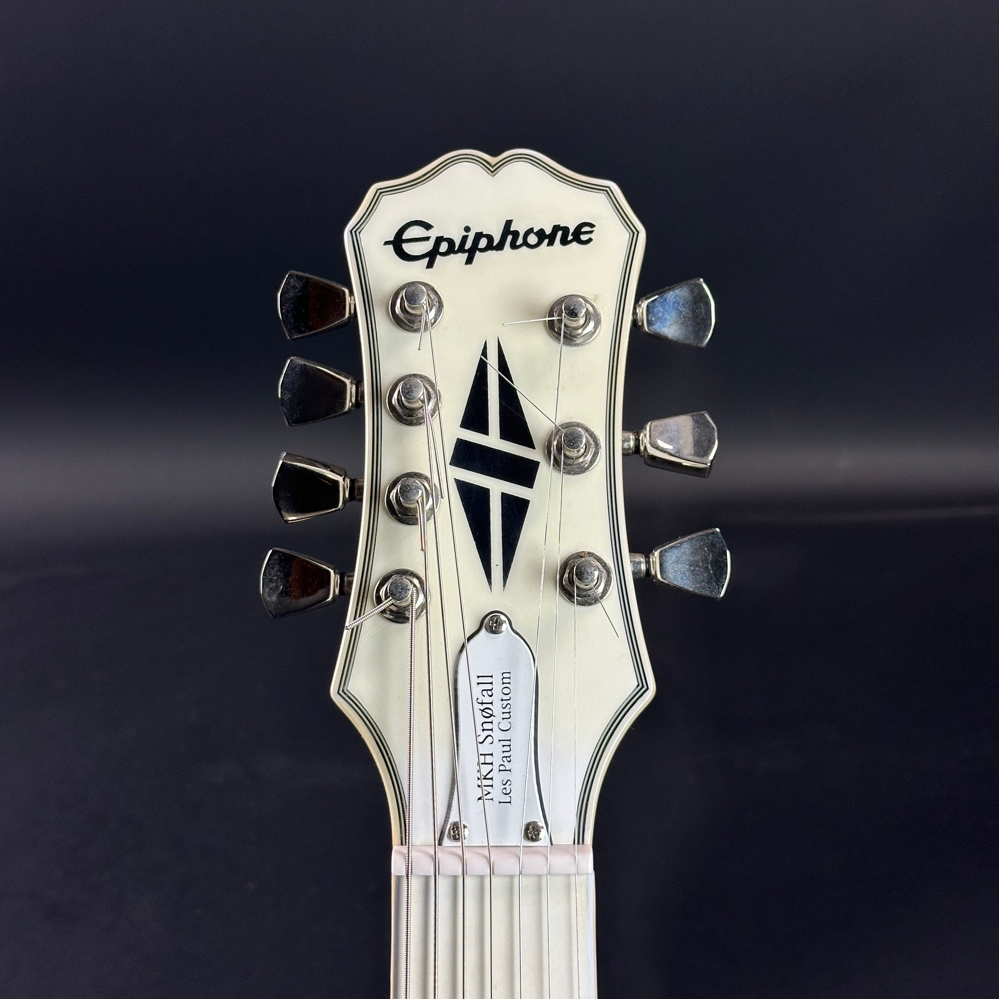 Front of headstock of Used Epiphone Matt Heafy "Snofall" Les Paul Custom White.