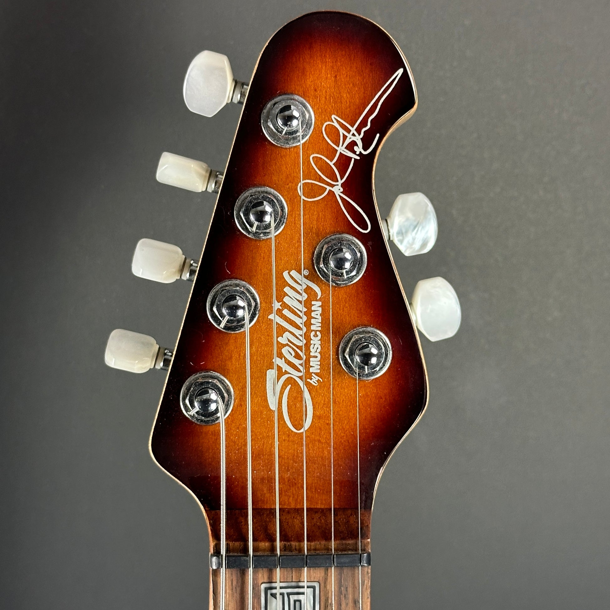 Front of headstock of Used Sterling by MusicMan JP100D.