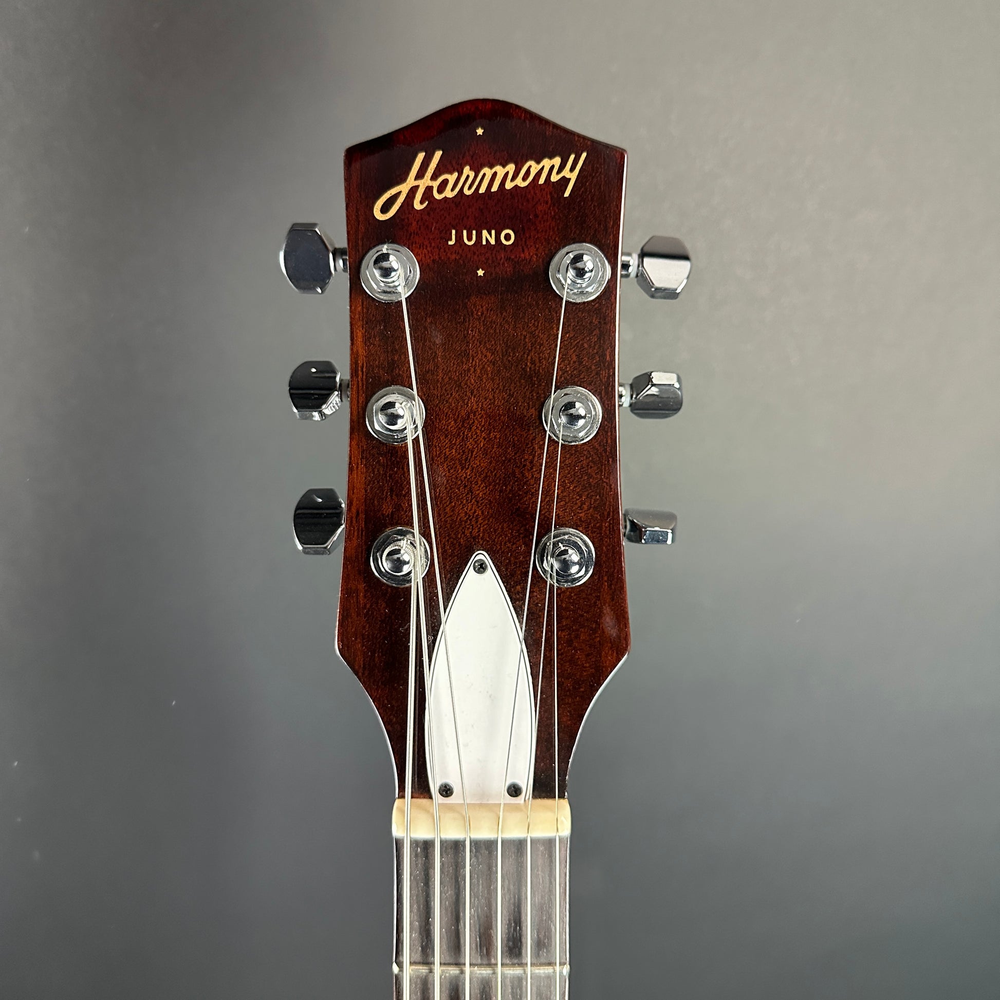 Front of headstock of Used Harmony Juno Transparent Brown Flame Maple.