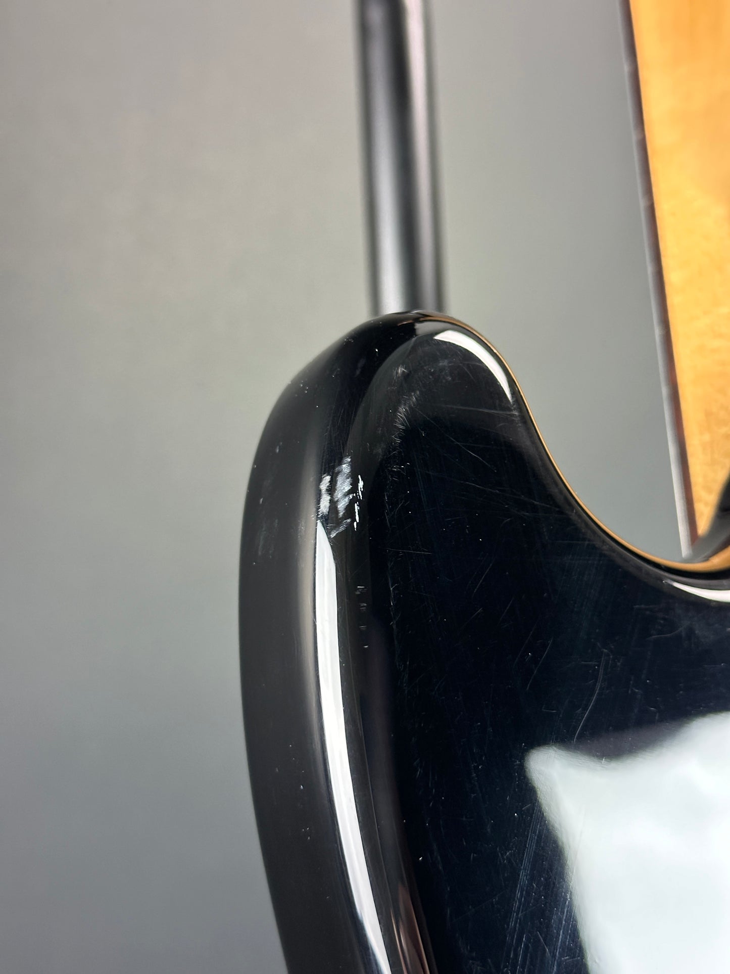 Scratch on back of upper horn of Used 1999 Squier Vista Musicmaster Black.