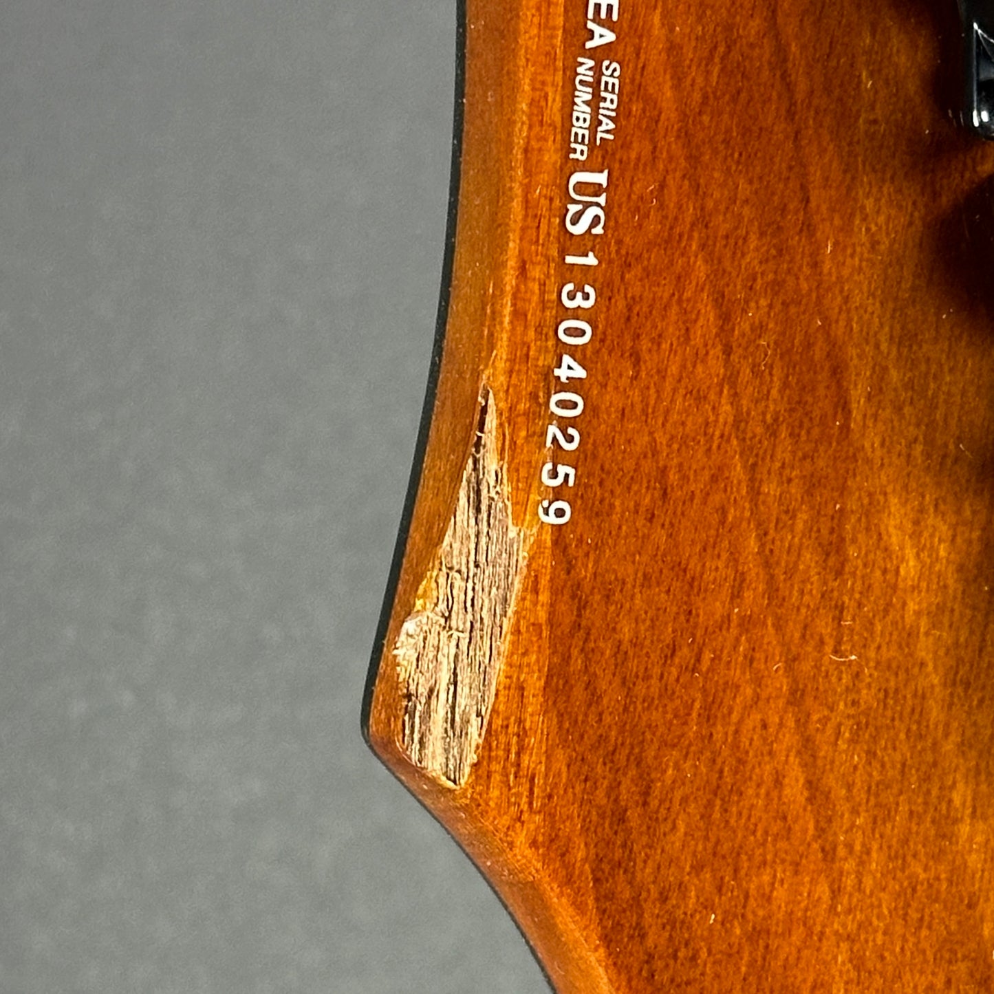 Chip on back of headstock of Used Dean Vendetta Amber.