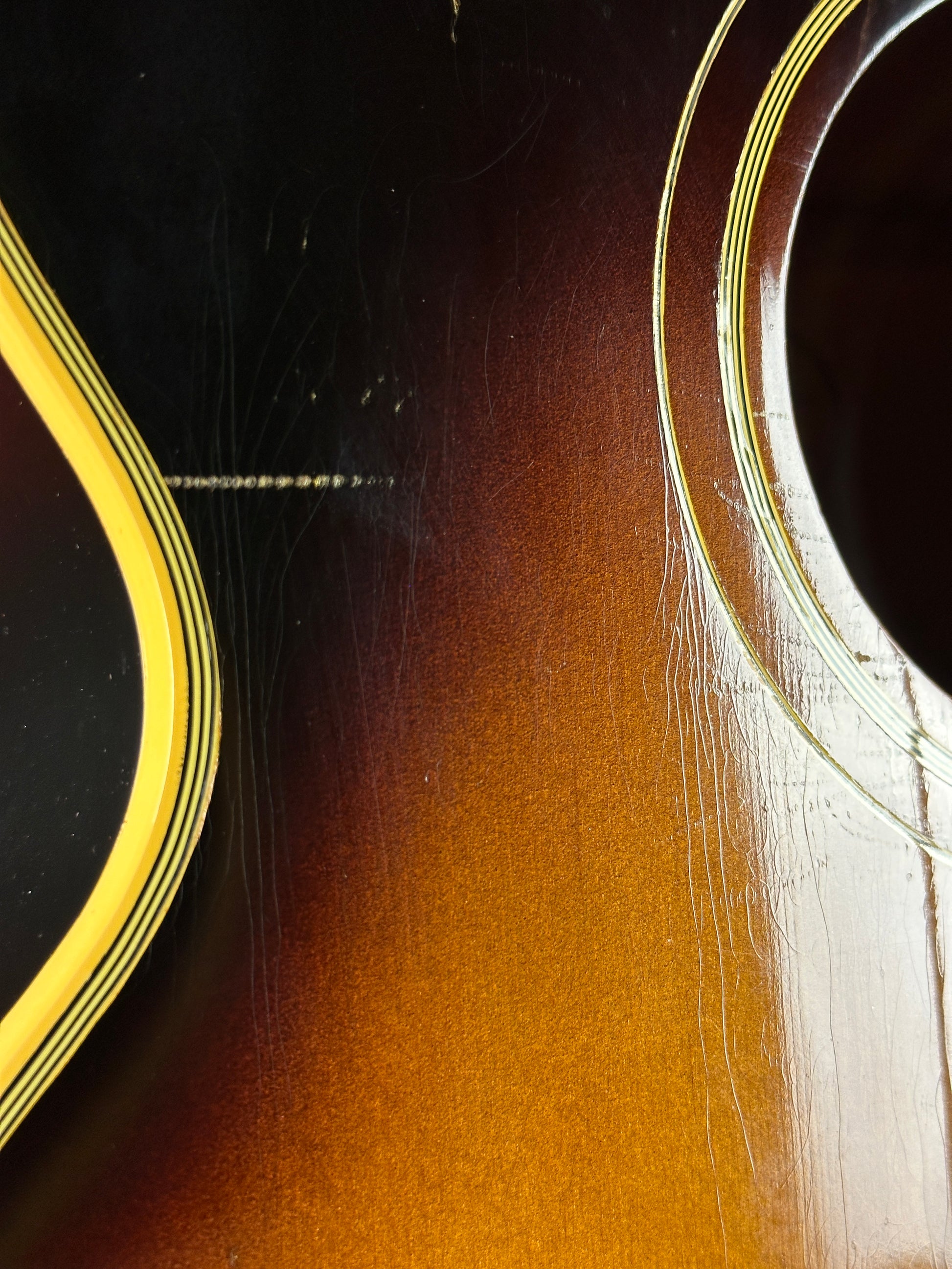 Wear near soundhole of Vintage 1954 Gibson SJ-200 Sunburst.