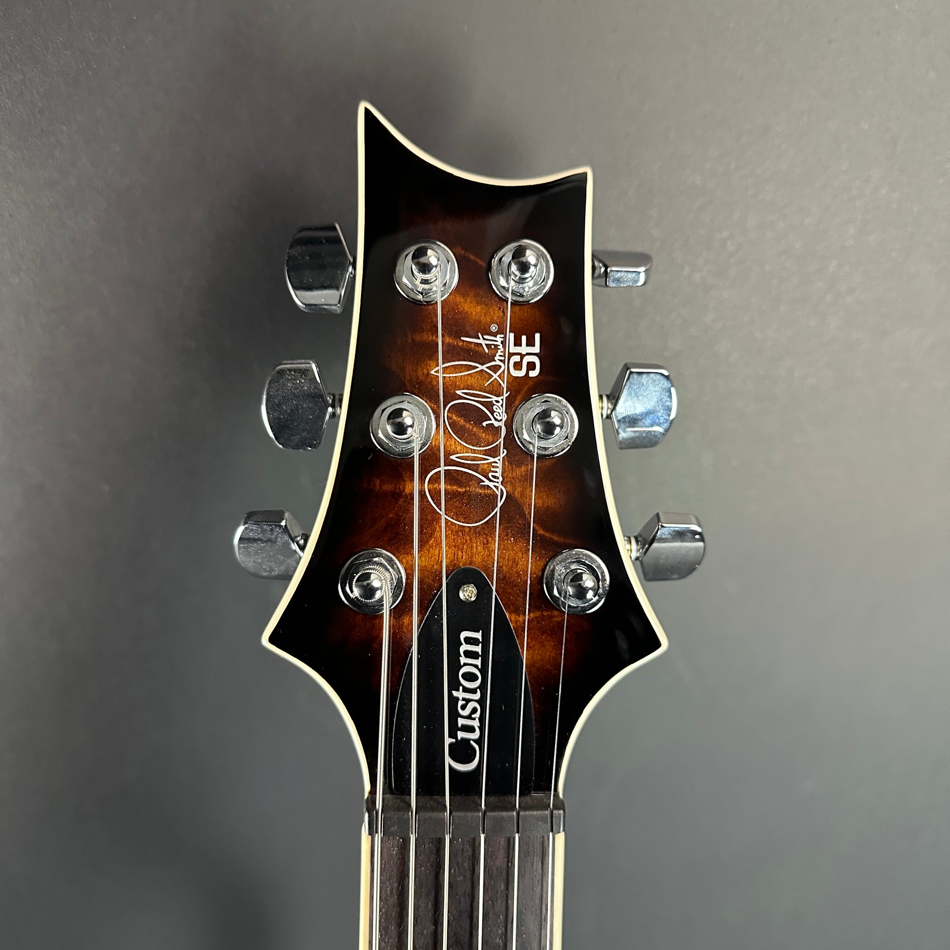 Front of headstock of Used PRS SE Custom 22 Semi-Hollow Black Gold Burst.