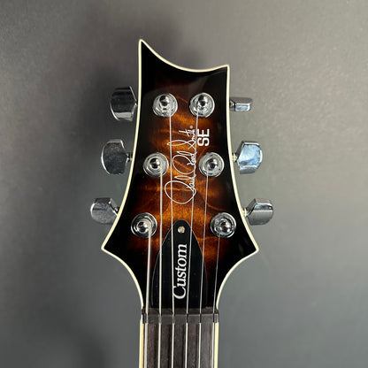 Front of headstock of Used PRS SE Custom 22 Semi-Hollow Black Gold Burst.