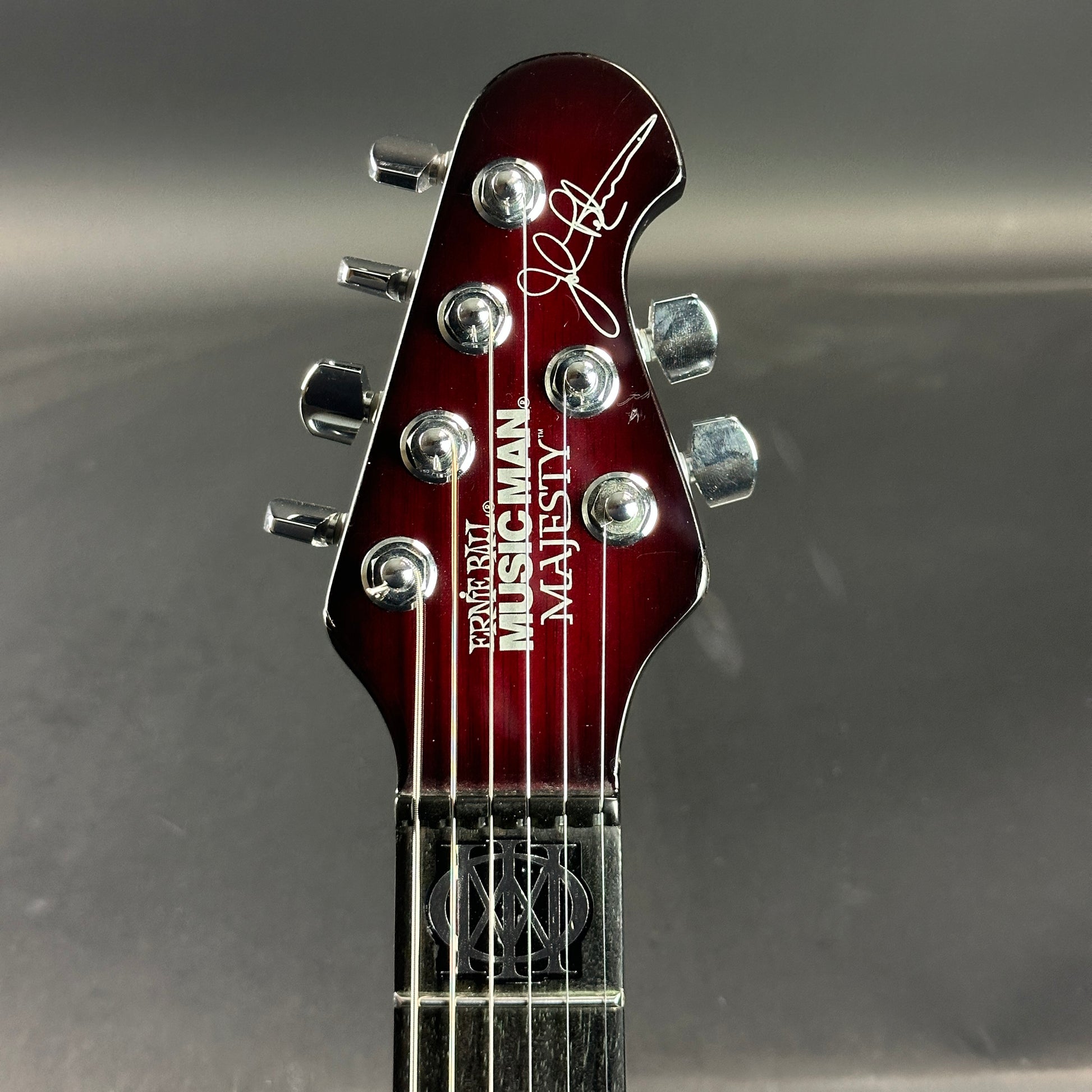 Front of headstock of Used Ernie Ball Petrucci Monarch Majesty Red.