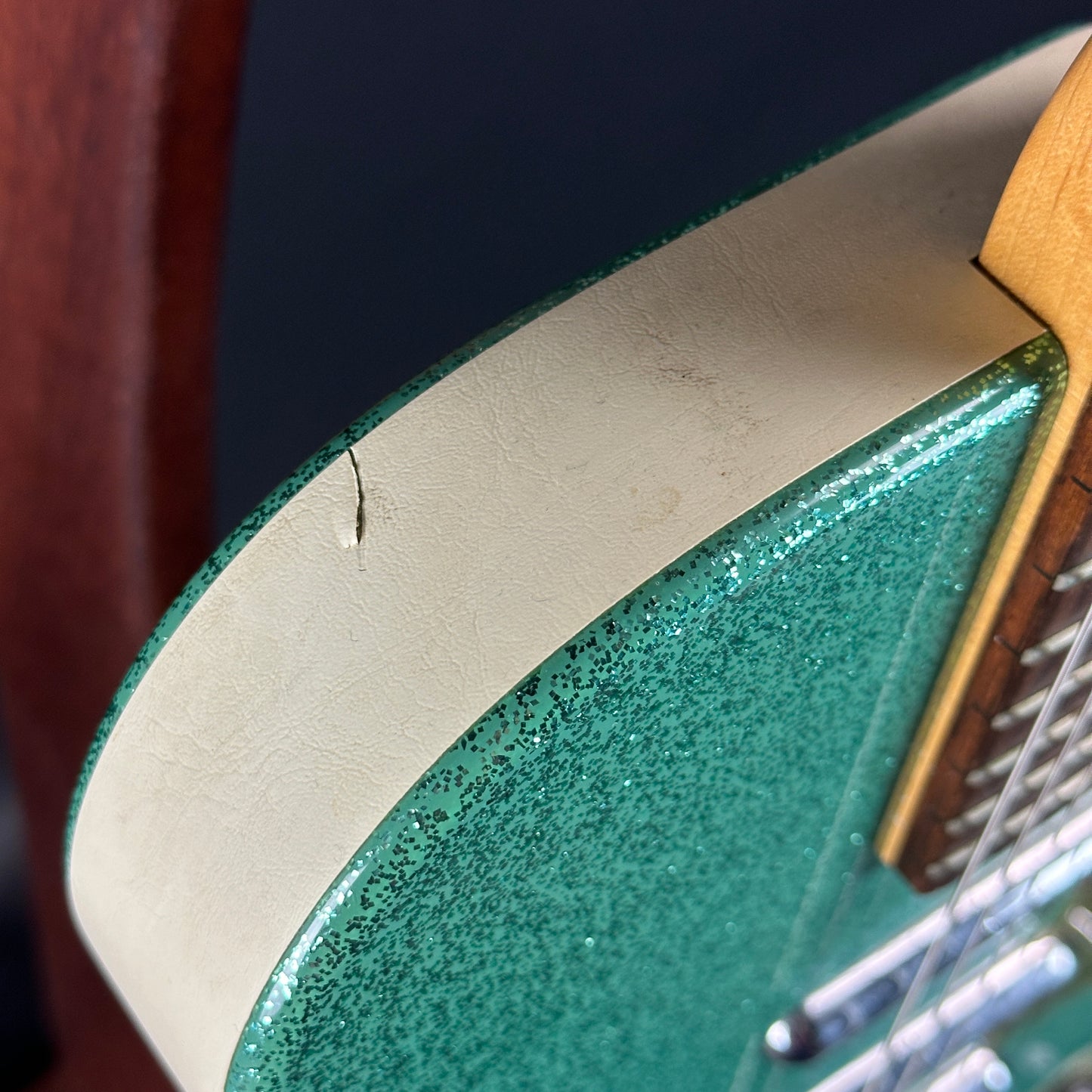 Crack in binding on body of Used Danelectro '56 U3 Green Sparkle.