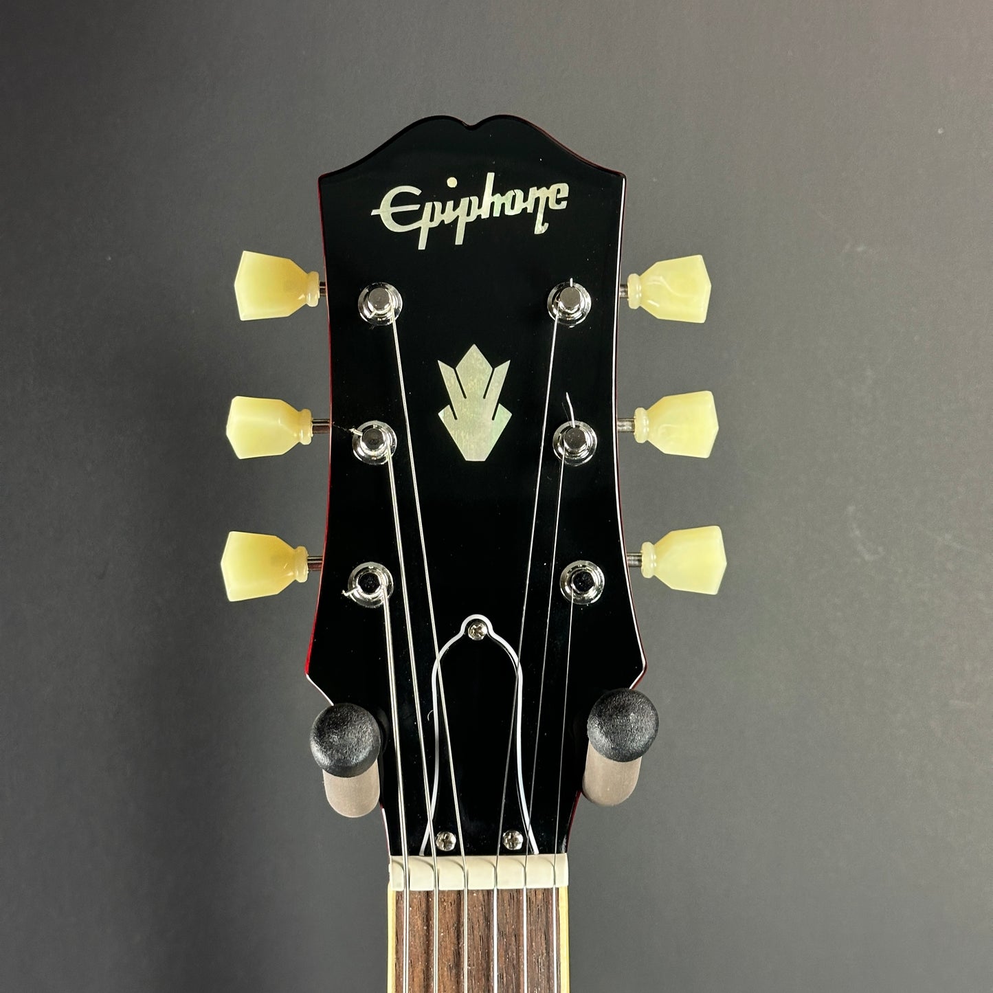 Front of headstock of Used Epiphone 335 IG Cherry Red.