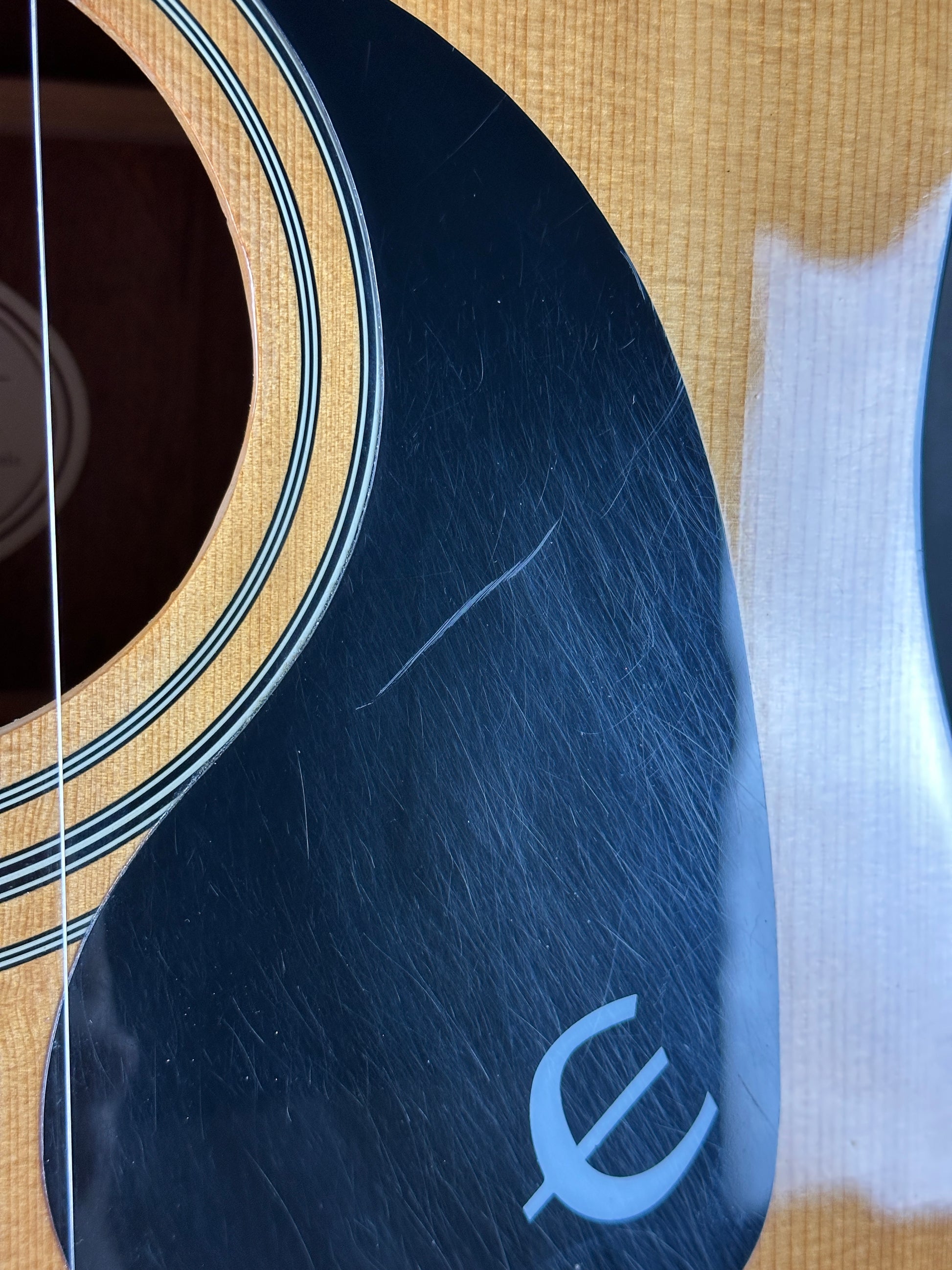 Scratches on pickguard of Used Epiphone PR-150 Acoustic Natural.