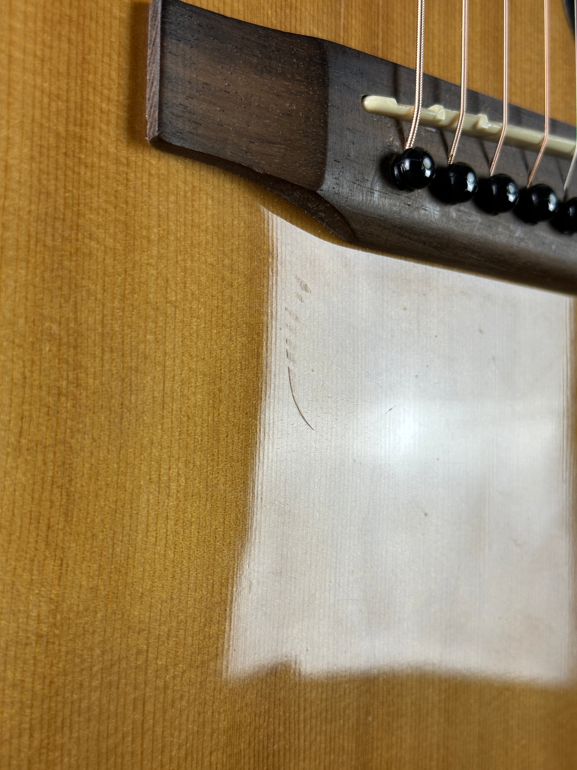 Scratch under bridge of Used Epiphone PR-150 Acoustic Natural.