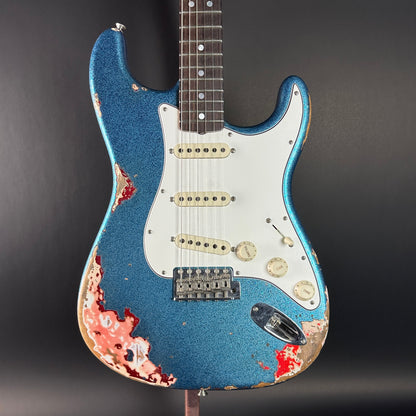 Front of Used Fender Custom Shop GC Tex Strat Heavy Relic Blue Sparkle Over Candy Apple Red.