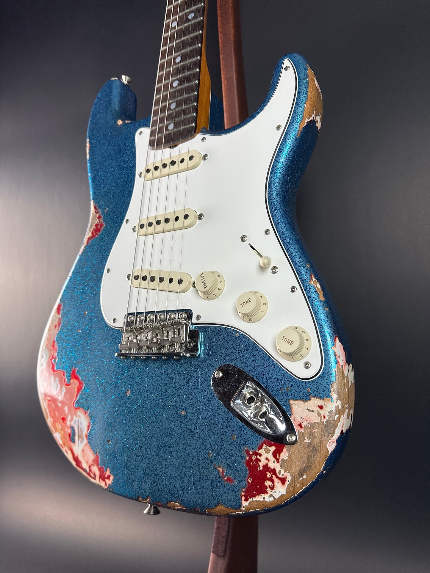 Front angle of Used Fender Custom Shop GC Tex Strat Heavy Relic Blue Sparkle Over Candy Apple Red.