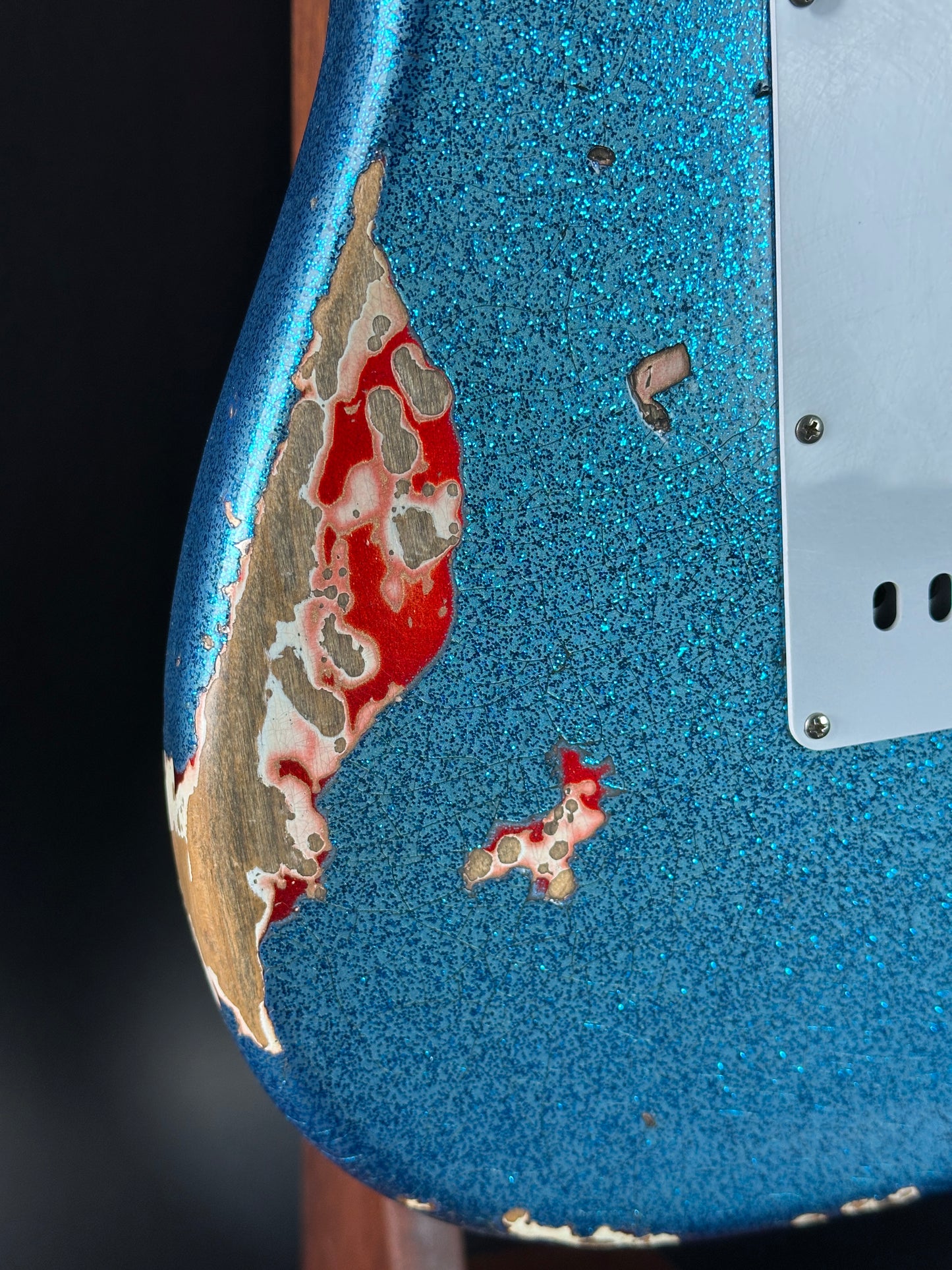 Detail on back of Used Fender Custom Shop GC Tex Strat Heavy Relic Blue Sparkle Over Candy Apple Red.