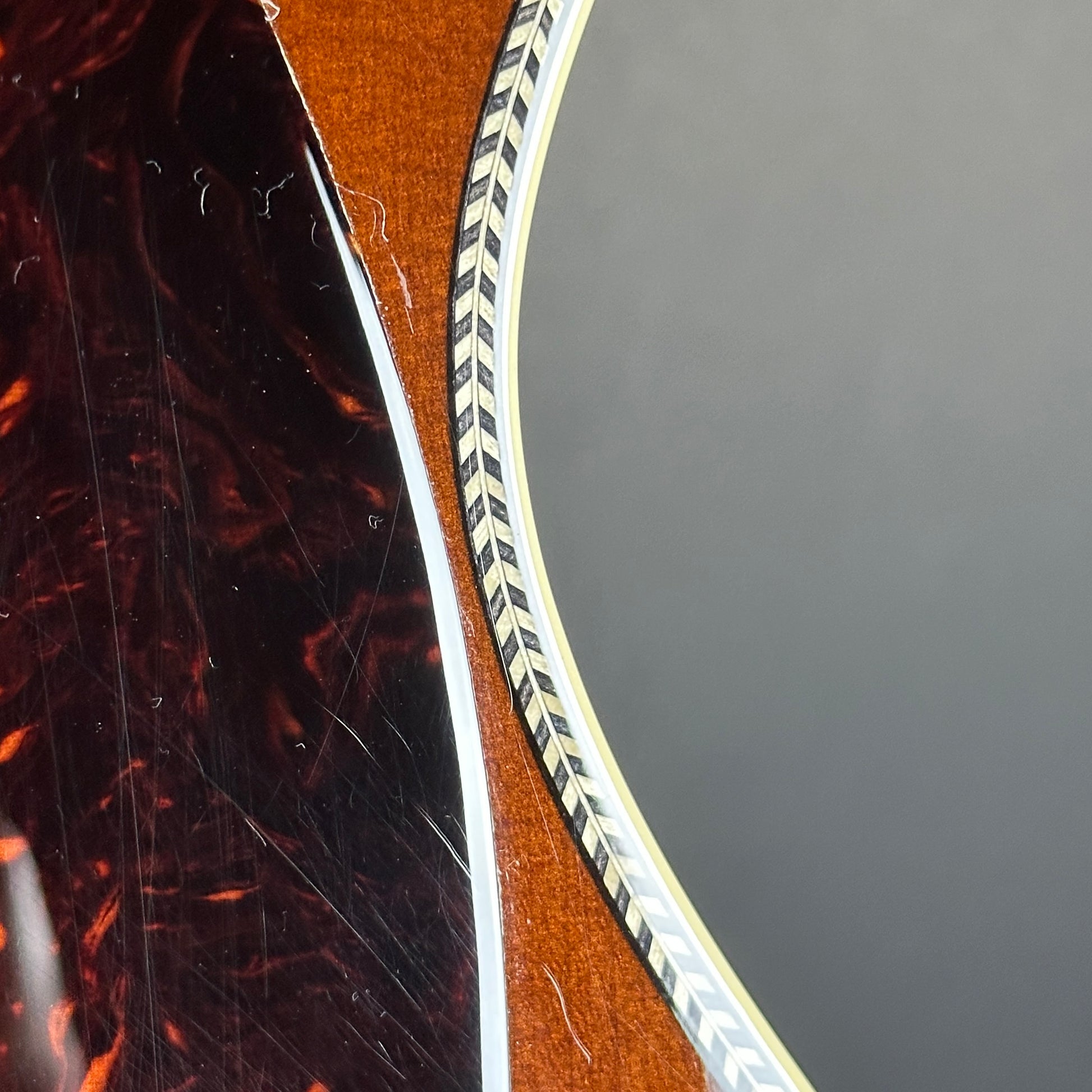 Scratches near pickguard of Used Martin 000-28 Ambertone.