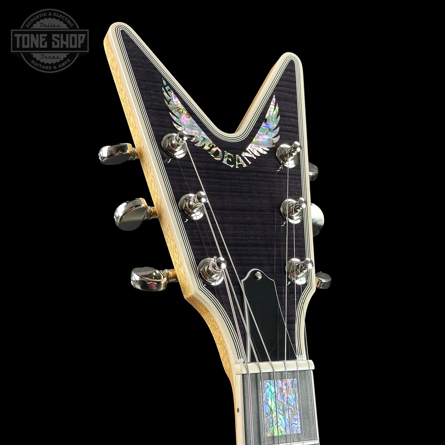 Front of headstock of Dean USA Custom Shop Cadillac Trans Black Korina/Flamed Maple Abalone.